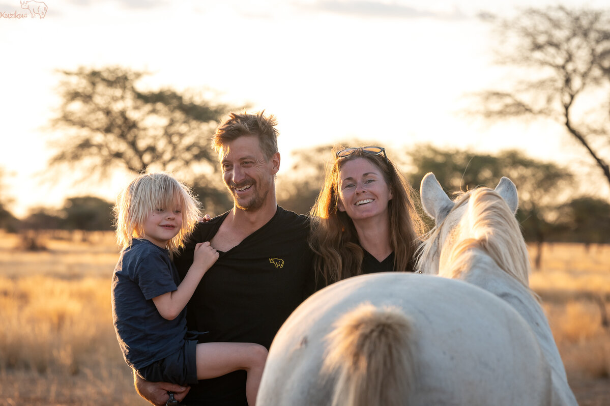 Familie mit Pferd bei Sonnenuntergang